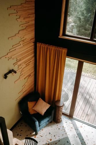 a living room with a chair and a window at Maciejówka Borki 33 in Borki