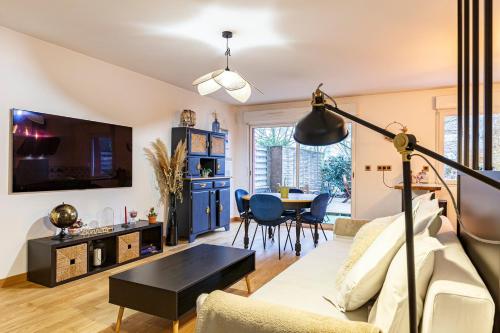 ein Wohnzimmer mit einem Sofa und einem Tisch in der Unterkunft Le Saint Cyr - bel appartement, parking & terrasse in Rennes