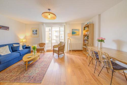 a living room with a blue couch and a table at Ty Azur, charmant 2 pièces avec balcon in Dinard