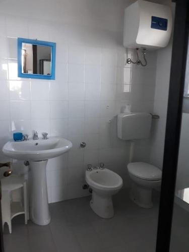 a white bathroom with a sink and a toilet at il patio mini appartamento in Pantelleria