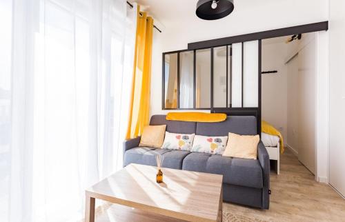 - un salon avec un canapé et un lit dans l'établissement L'Ivoire - Joli appartement - 1 chambre avec, à Rennes