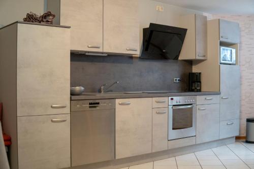 a kitchen with stainless steel cabinets and a sink at Ferienwohnung Haus Biggi in Gransdorf