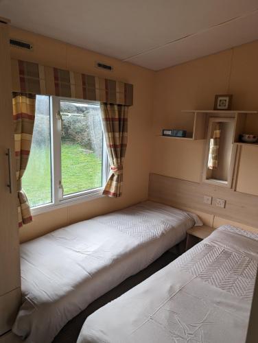 two beds in a room with a window at 64 Wide Horizon in Aberaeron