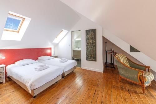 Un dormitorio con 2 camas y una silla. en Minihic - Belle maison 3 chambres- Proche Mer, en Saint-Malo