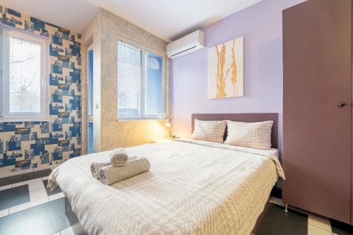 Spacious apartment in the heart of Studentski grad في صوفيا: غرفة نوم عليها سرير وفوط