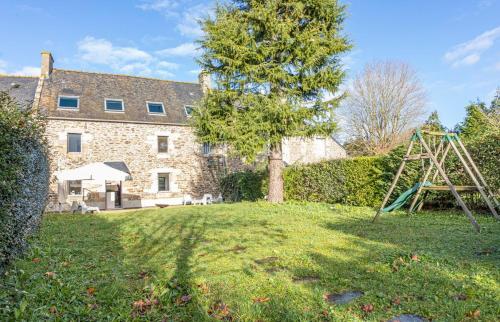 une maison avec un arbre et une balançoire dans l'établissement Villa Asselin - Belle maison en pierre -4 chambres, à Beaussais sur Mer