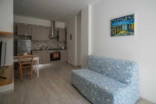 ein Wohnzimmer mit einem Sofa und einer Küche in der Unterkunft CASA STELLA in Comiso