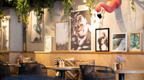 a restaurant with tables and pictures on the wall at Hotel Indigo Antwerp City Centre by IHG in Antwerp