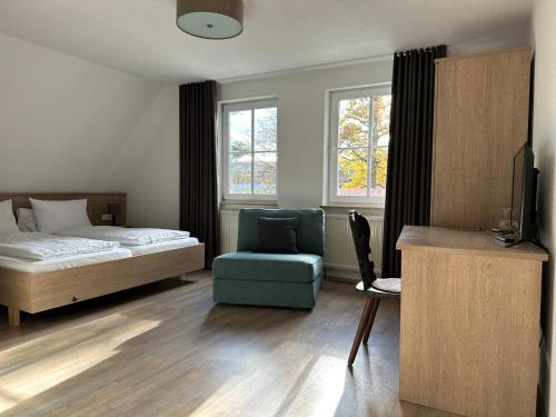 a bedroom with a bed and a chair and window at Waldhotel Eichenhof in Aalen
