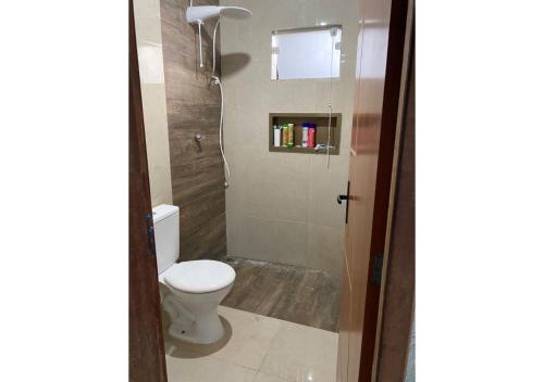 a bathroom with a toilet and a shower at Casa temporada Arembepe Ba in Camaçari