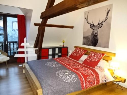 a bedroom with a bed and a deer picture on the wall at Résidence Maison Mitoyenne - Maison 10 personnes village de GUCHEN MAE-9594 in Guchen