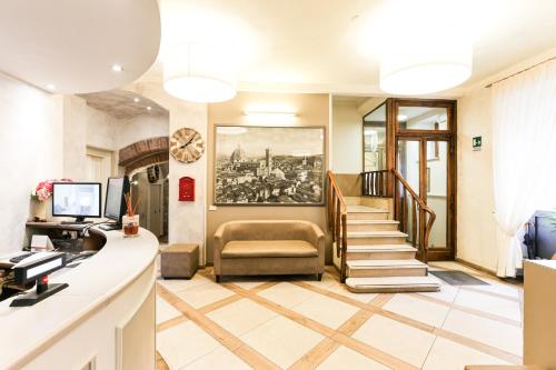 a lobby with a staircase and a reception desk at Albergo Firenze in Florence