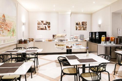 a restaurant with tables and chairs and a counter at Albergo Firenze in Florence