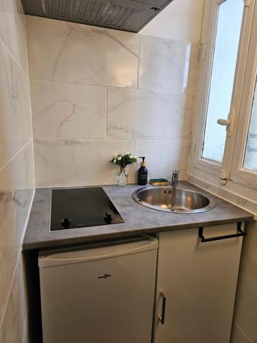 La salle de bains est pourvue d'un lavabo et d'une fenêtre. dans l'établissement COSY BALI, à Bondy