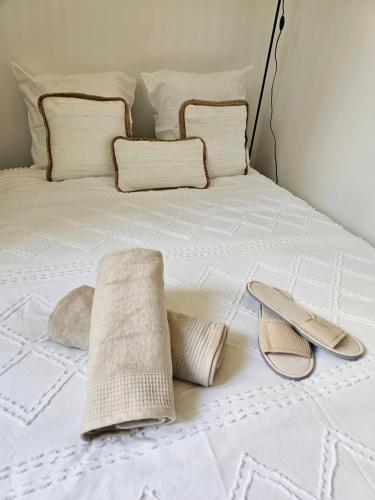 - un lit avec 2 oreillers et des serviettes dans l'établissement COSY BALI, à Bondy