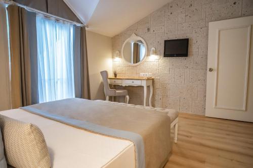 a bedroom with a bed and a desk and a mirror at Mark Warner Phokaia Beach Resort in Foca