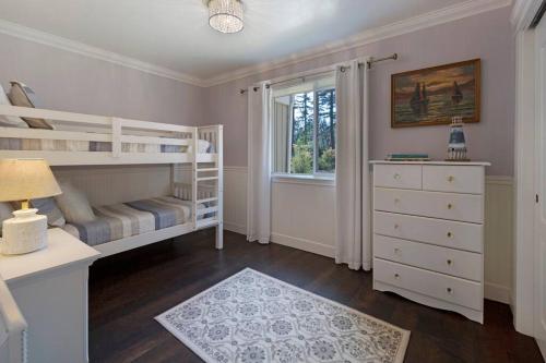 a bedroom with bunk beds and a dresser and a window at Secluded 4BR Nestled in Woods-Hot Tub/Dog Friendly in Friday Harbor