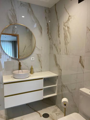 a bathroom with a sink and a mirror at OPORTO Suites in Moreira