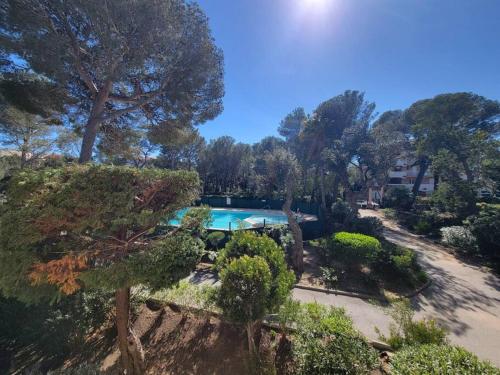 une vue aérienne d'une piscine dans un jardin dans l'établissement L'Appart St Aygulf, 5mn à pied mer, piscine, tennis, à Fréjus