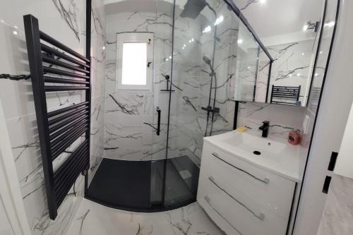 une salle de bain blanche avec une douche et un lavabo dans l'établissement L'Appart St Aygulf, 5mn à pied mer, piscine, tennis, à Fréjus