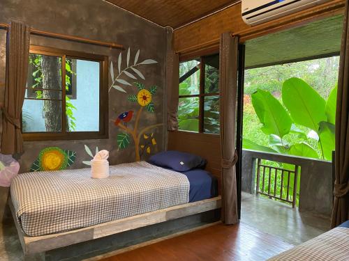 a bedroom with a bed in a room with windows at Shaya Resort in Pai