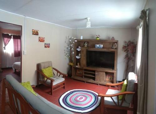 a living room with a television and a table and chairs at Vivienda familiar Doña Marta Churin in Churín