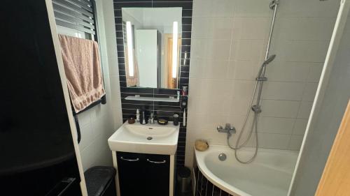 a small bathroom with a sink and a shower at Parkside Modern Haven - Spacious & Serene in Košice in Košice