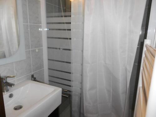 La salle de bains est pourvue d'un lavabo et d'un rideau de douche blanc. dans l'établissement Résidence Hameau Du Soleil - APPARTEMENT 4 PERSONNES VIELLE-AURE MAE-3434, à Vielle-Aure