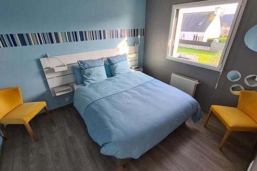une chambre avec un lit et deux chaises et une fenêtre dans l'établissement Les Marquises - bord de mer, à Roscoff