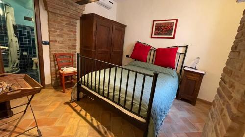 a bedroom with a bed with red pillows at Il Giardino degli Ulivi in Chiusure