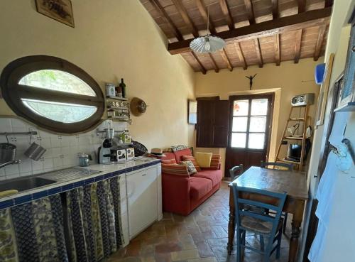 een keuken met een wastafel en een woonkamer bij Il Giardino degli Ulivi in Chiusure