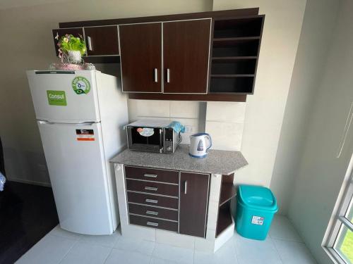 a small kitchen with a refrigerator and a microwave at London Family home in Cochabamba