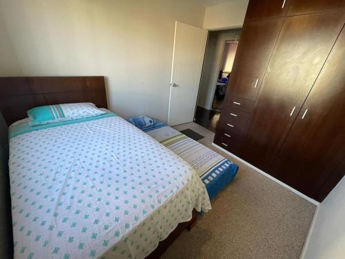 コチャバンバにあるLondon Family homeの小さなベッドルーム(ベッド1台、ドレッサー付)