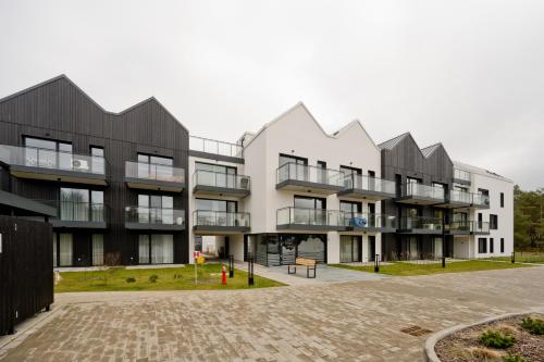 an apartment building with black and white at Apartament Orlando w Porto Łeba 350m od morza in Łeba
