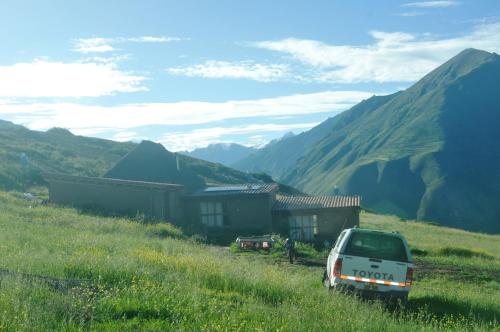 a white car parked in front of a mountain at Pampachayoq - Mountain retreat in Urubamba