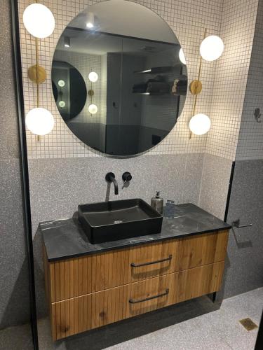 a bathroom with a black sink and a mirror at Sima suite 3 in Ashdod