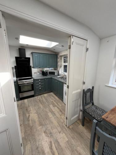a kitchen with green cabinets and a stove top oven at Seagull studio in Felixstowe