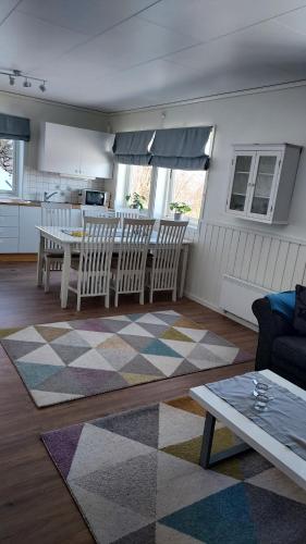 een woonkamer met een tafel en stoelen en een keuken bij Solbakken 27 Apartment in Lyngseidet