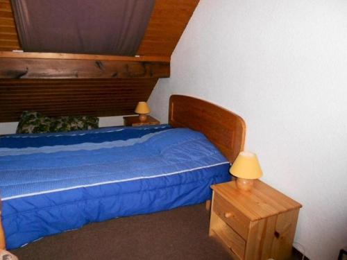 - une chambre avec un lit bleu et une tête de lit en bois dans l'établissement Résidence Hameau Des Thermes I - Appartement 6 personnes proche des Thermes MAE-6104, à Saint-Lary-Soulan