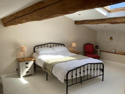 um quarto com uma cama e uma cadeira vermelha em La Ruche em Theil-Rabier