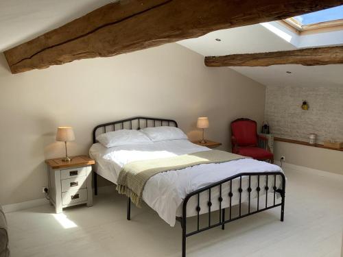 a bedroom with a bed and a red chair at La Ruche in Paizay-Naudouin