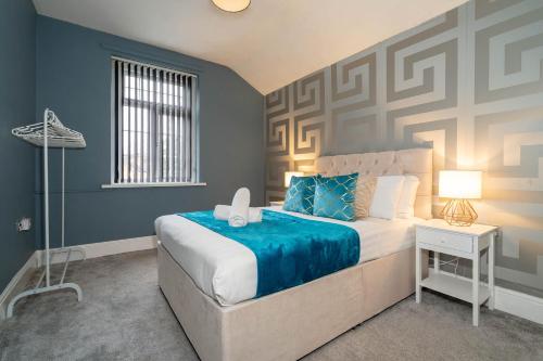 una camera con un grande letto con una parete con accento blu di Large 7 Bedroom Townhouse with Parking - WIFI & Netflix - Sleeps 16 - 568P a Birmingham