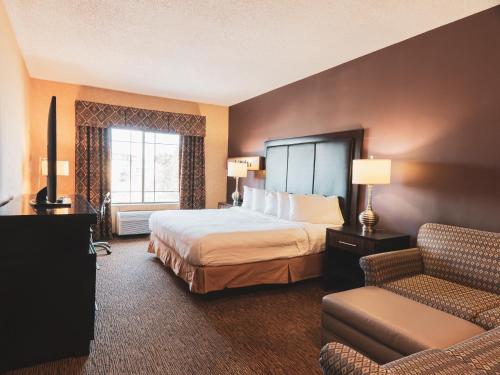 une chambre d'hôtel avec un lit et un canapé dans l'établissement Wildwood Lodge, à Pewaukee