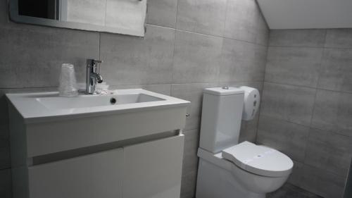 a bathroom with a white sink and a toilet at Hotel Senhor de Matosinhos in Matosinhos