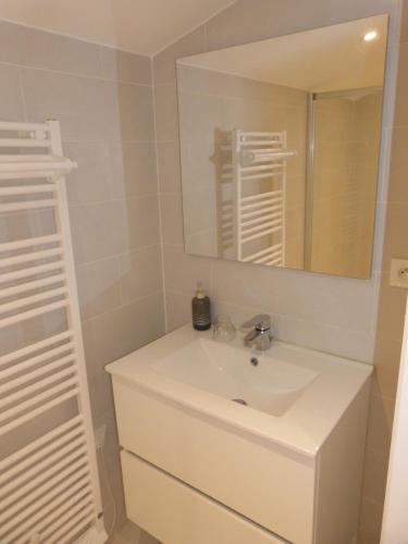 a bathroom with a white sink and a mirror at Prieuré de Grignan in Grignan