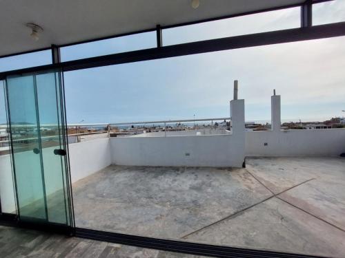 Departamento exclusivo Punta Negra في بونتا نيغرا: اطلالة من الشرفة على مبنى بأبواب زجاجية