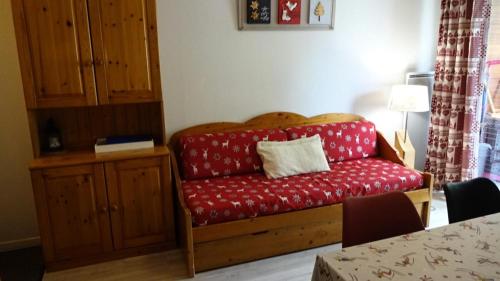 a red couch in a living room with a table at Résidence Soleil D'aure - Appartement 4 personnes à deux pas du centre MAE-3564 in Cadeilhan-Trachère