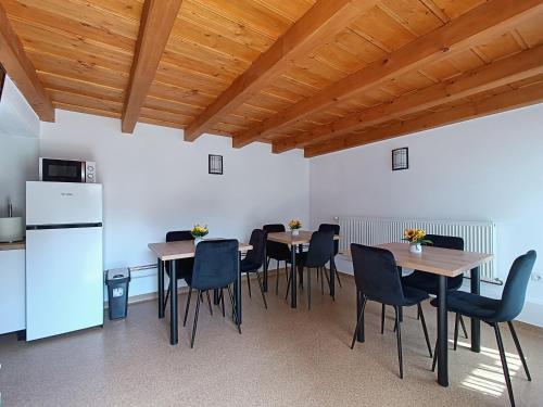 a dining room with tables and chairs and a refrigerator at Casa de Vacanță Zabpatak Vendégház in Rimetea