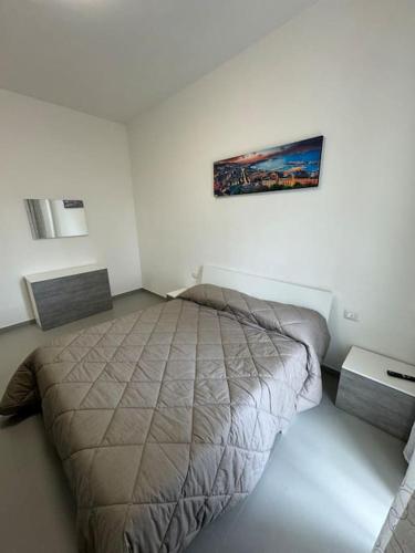 a bedroom with a bed and a painting on the wall at CASA LUISA - Comfortable APT in San Vitaliano 