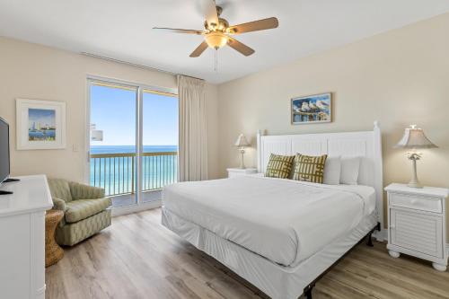 a white bedroom with a bed and a balcony at Calypso Resort and Towers #801-W by Book That Condo in Panama City Beach